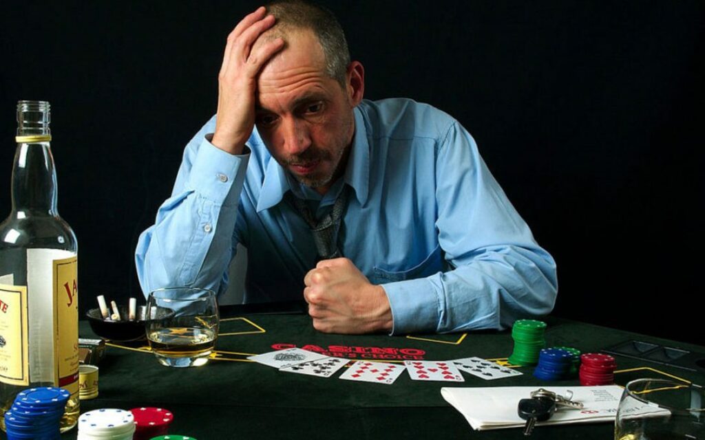 Problem gambling addict sadly holding head after losing the game